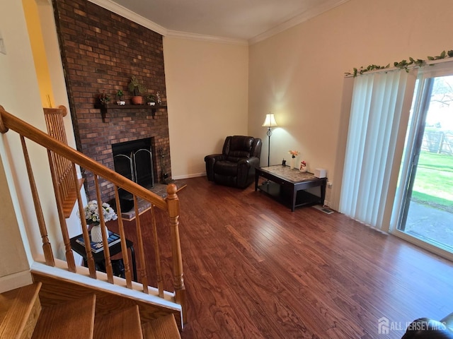 living area with stairway, ornamental molding, a fireplace, and wood finished floors