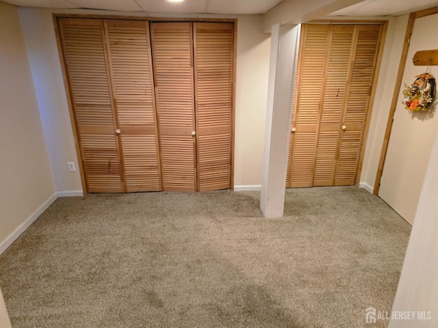 unfurnished bedroom with carpet floors, baseboards, and multiple closets