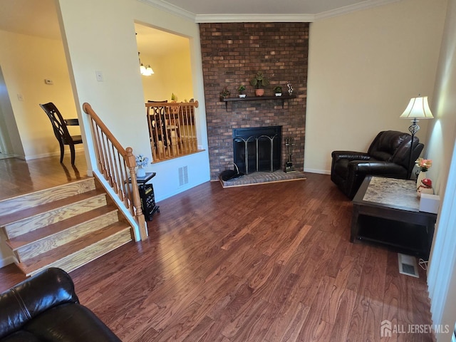 living room featuring a fireplace, baseboards, wood finished floors, visible vents, and ornamental molding
