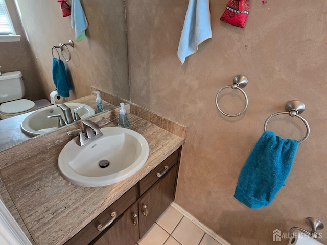 bathroom with tile patterned flooring, toilet, and vanity