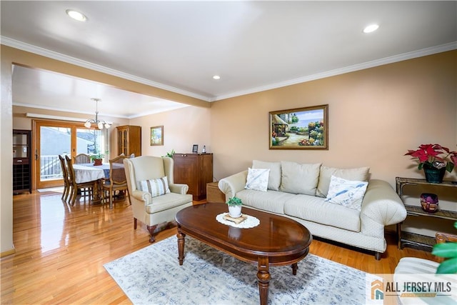 living area with light wood finished floors, recessed lighting, crown molding, and an inviting chandelier