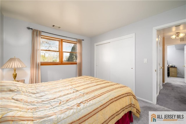 carpeted bedroom with a closet, visible vents, and baseboards