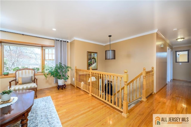 corridor with wood finished floors, crown molding, an upstairs landing, and baseboards