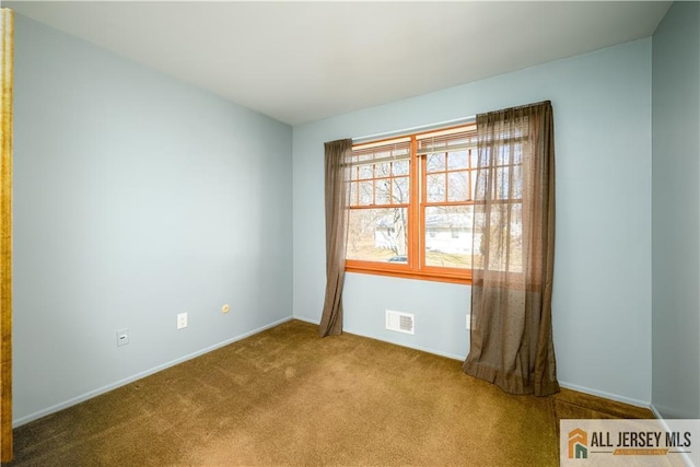 spare room featuring visible vents, baseboards, and carpet flooring