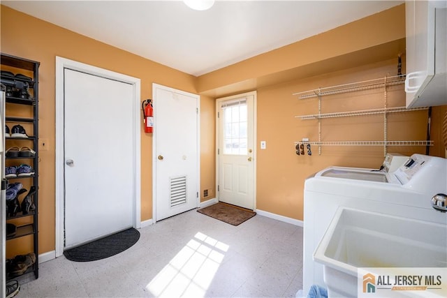 clothes washing area featuring tile patterned floors, laundry area, baseboards, and separate washer and dryer