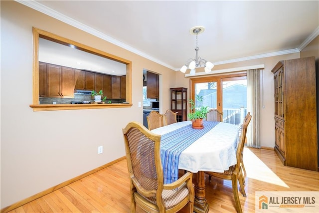 dining space with light wood-style flooring, baseboards, an inviting chandelier, and ornamental molding