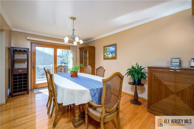 dining room with a chandelier, baseboards, light wood-style floors, and ornamental molding