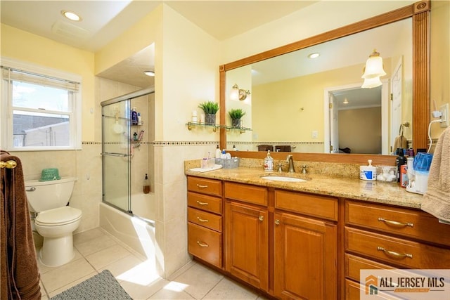 full bath featuring vanity, tile walls, toilet, and tile patterned flooring