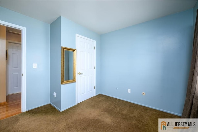 unfurnished bedroom with baseboards and carpet