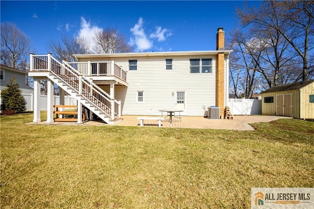 rear view of house featuring a patio, an outbuilding, fence, a storage shed, and central air condition unit