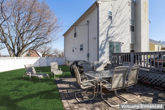 rear view of house with a deck, a patio, a lawn, and a fenced backyard