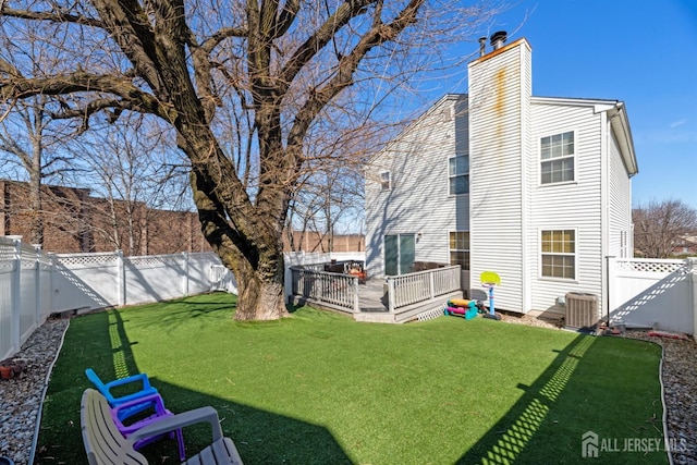 view of yard with a wooden deck, central AC, and a fenced backyard