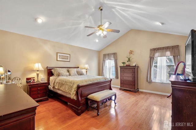 bedroom featuring lofted ceiling, multiple windows, light wood-style floors, and baseboards