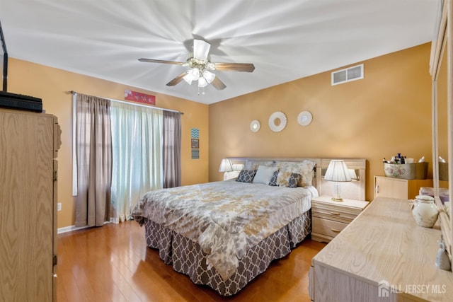 bedroom featuring wood finished floors, visible vents, and ceiling fan