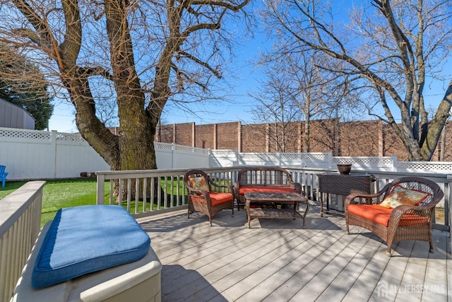 wooden terrace with a fenced backyard