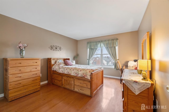 bedroom with baseboards and light wood finished floors