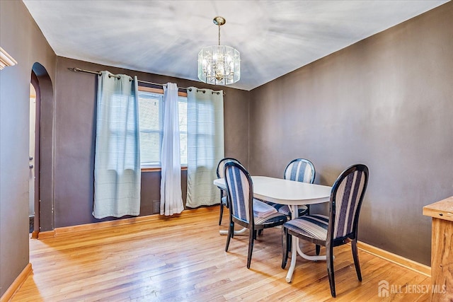 1332 Crescent Ave, Roselle, NJ 07203 - dining room with arched walkways, wood finished floors, a chandelier, and baseboards