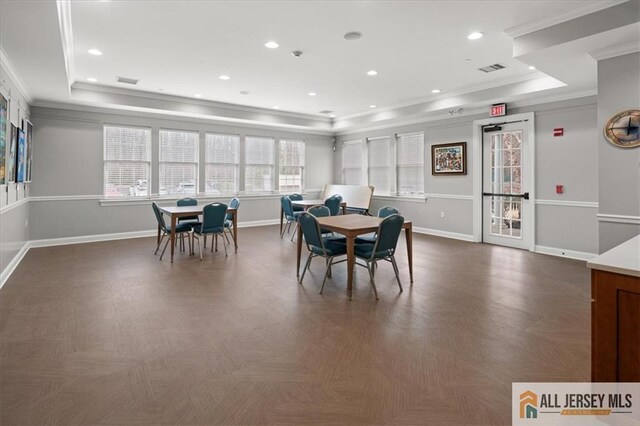 dining room featuring crown molding, dark parquet flooring, and a raised ceiling