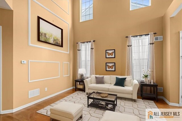 living room with a high ceiling and light hardwood / wood-style floors