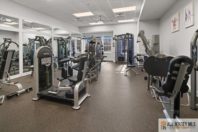 gym with ceiling fan and a drop ceiling