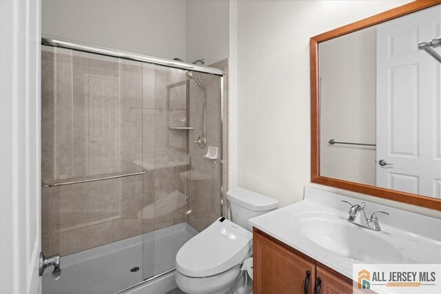 bathroom with vanity, toilet, and a shower with shower door