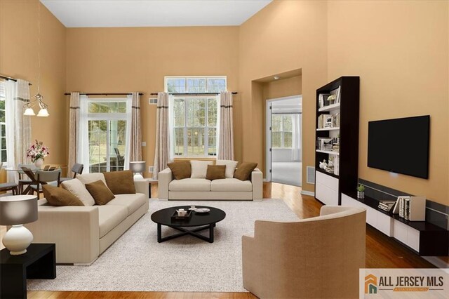 living room with hardwood / wood-style floors and a high ceiling