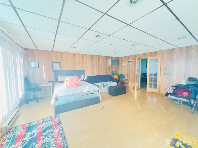 910 Roanoke Ave, Hillside, NJ 07205 - bedroom featuring a baseboard heating unit, french doors, wooden walls, a paneled ceiling, and wood finished floors