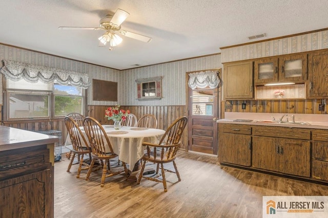 14 Fisher Ave, Middlesex, NJ 08846 - dining space with ornamental molding, wallpapered walls, light wood-type flooring, ceiling fan, and a textured ceiling