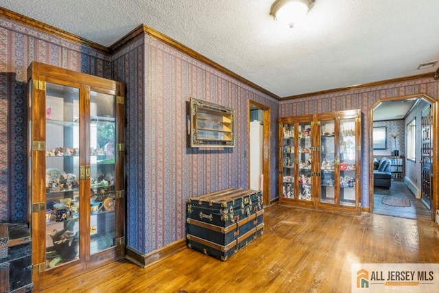 14 Fisher Ave, Middlesex, NJ 08846 - spare room with crown molding, wood finished floors, wallpapered walls, a textured ceiling, and arched walkways