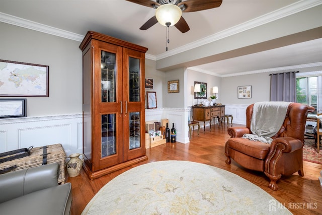 7 Manor Ct, Old Bridge, NJ 08857 - sitting room featuring crown molding, wood finished floors, a wainscoted wall, ceiling fan, and a decorative wall