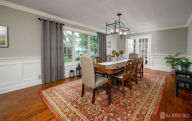 7 Manor Ct, Old Bridge, NJ 08857 - dining area with a chandelier, ornamental molding, a wainscoted wall, wood finished floors, and a decorative wall