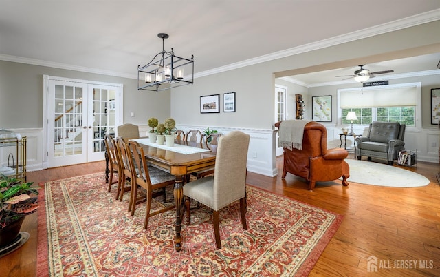 7 Manor Ct, Old Bridge, NJ 08857 - dining space featuring crown molding, french doors, wood finished floors, a decorative wall, and a chandelier