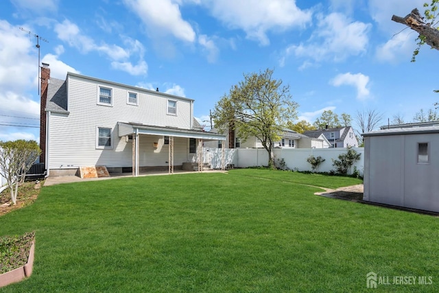 rear view of property featuring a chimney, a patio, and an outdoor structure
