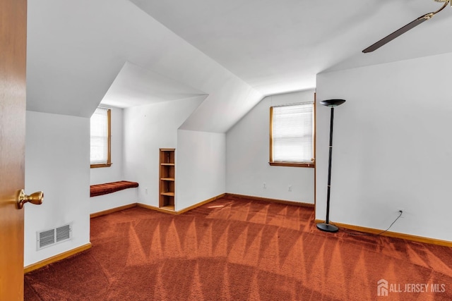 additional living space with carpet floors, baseboards, vaulted ceiling, and a ceiling fan