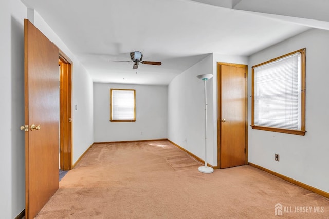 bonus room featuring light carpet, a ceiling fan, and baseboards