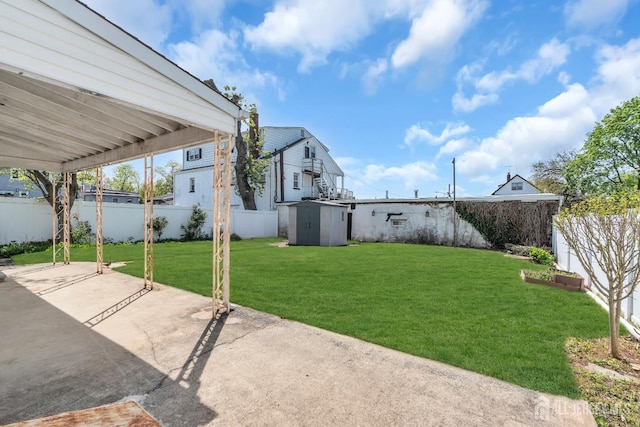 view of yard featuring a patio area, a shed, and an outbuilding