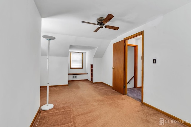 additional living space with light carpet, a ceiling fan, baseboards, and lofted ceiling