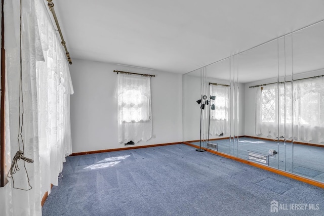 carpeted empty room featuring baseboards