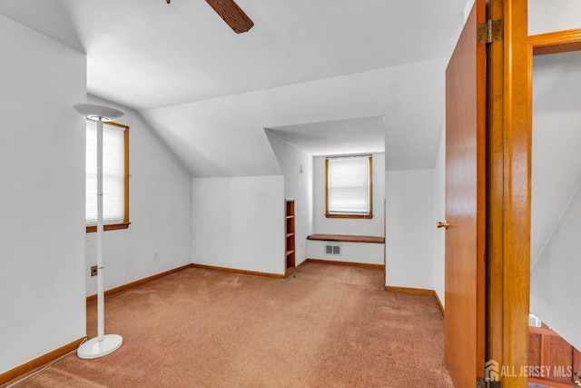 additional living space featuring carpet flooring, ceiling fan, baseboards, and vaulted ceiling