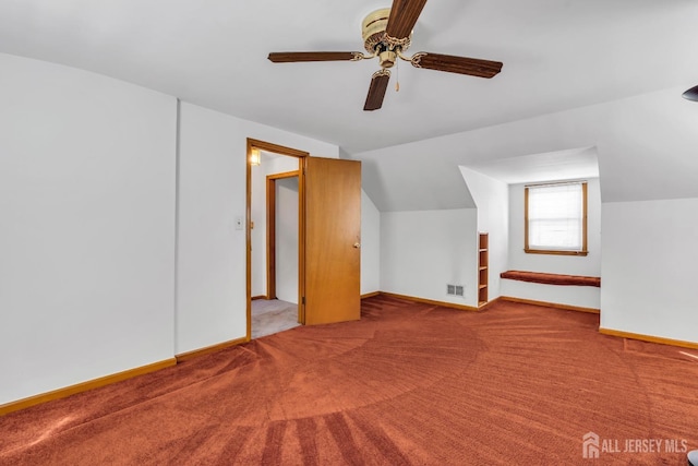 additional living space featuring carpet floors, baseboards, a ceiling fan, and vaulted ceiling