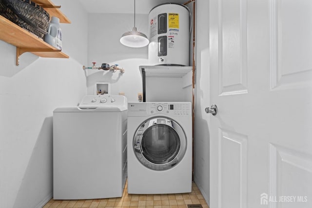 clothes washing area with laundry area, water heater, and independent washer and dryer