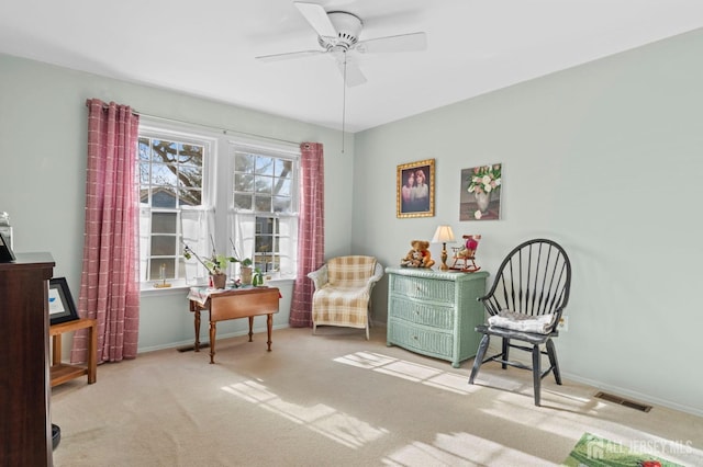 living area with ceiling fan, carpet, visible vents, and baseboards