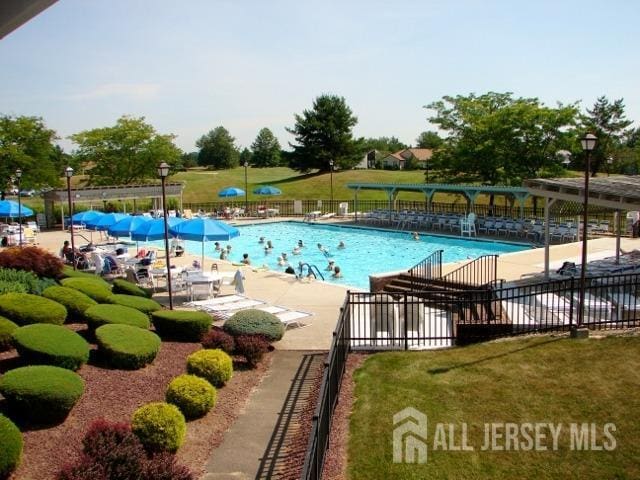 pool featuring fence and a patio