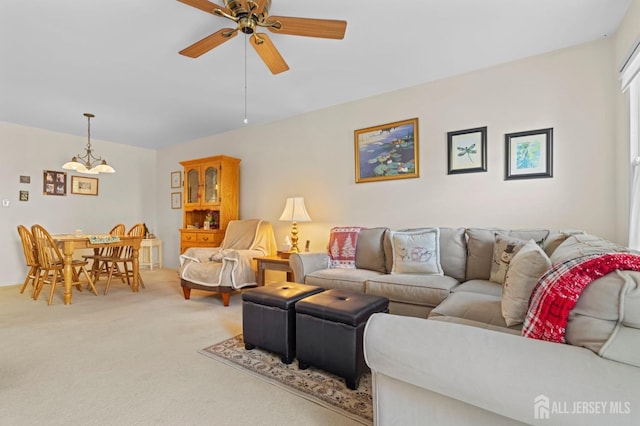 living area with light carpet and ceiling fan