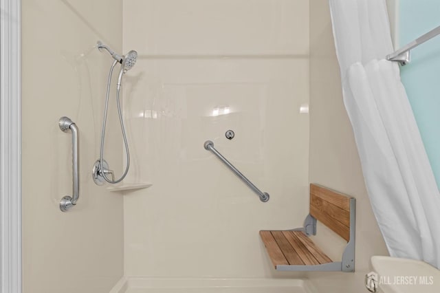 bathroom with a shower with shower curtain and toilet