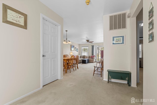 hall with carpet, visible vents, and baseboards