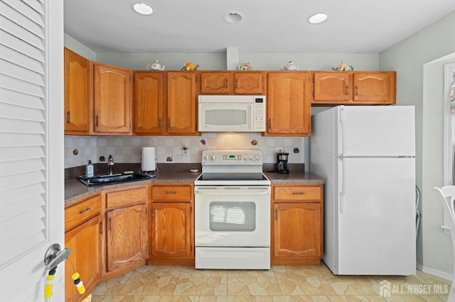 kitchen featuring white appliances, brown cabinetry, dark countertops, and tasteful backsplash