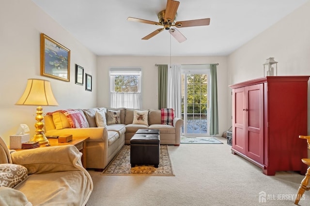 living area featuring light carpet and a ceiling fan