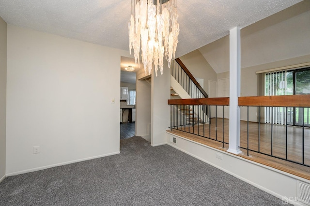 carpeted empty room featuring lofted ceiling and a textured ceiling