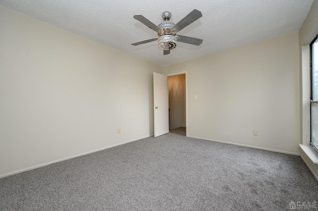 carpeted spare room featuring ceiling fan and a textured ceiling